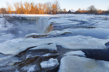 Partially frozen waterfall Jagala juga, Estonia. Water falling from fractured limestone plate