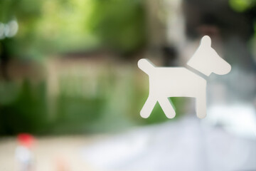 Dog sticker on glass door in focus, blurred glass and background. Pets friendly