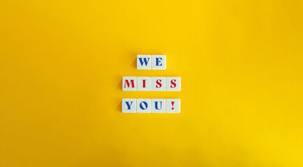 We Miss You Phrase and Marketing Strategic Tool or Tactic for Re-engaging with Customers. Text on Block Letter Tiles on Yellow Orange Background.