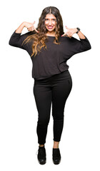 Beautiful young woman with long hair looking confident with smile on face, pointing oneself with fingers proud and happy.