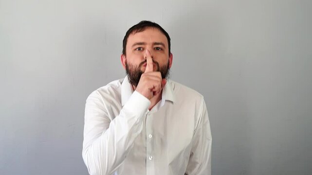 Man Signaling to Be Quiet with Finger to Lips And Stop Talking. Silence gesture