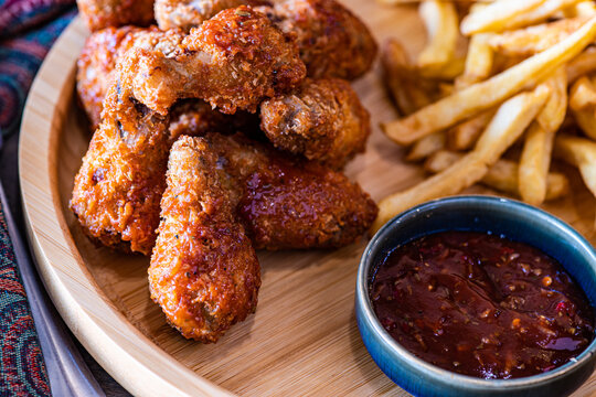 Top view of fried chicken hips with french fries and BBQ sauce