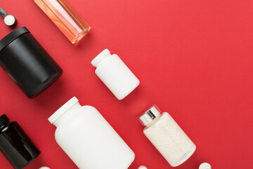 Jars with protein powder on color background, top view. Sports nutrition concept