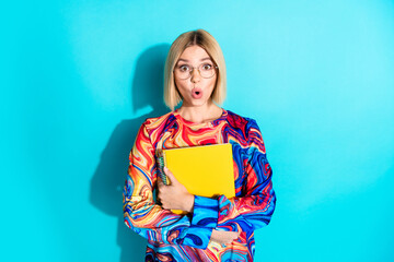 Photo of impressed girl with bob hair dressed print shirt hold copybook astonihsed staring open...