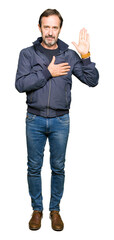Middle age handsome man wearing a jacket Swearing with hand on chest and open palm, making a...