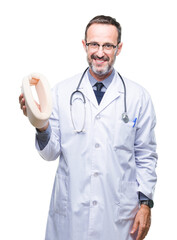 Middle age senior hoary doctor man holding neck collar over isolated background with a happy face standing and smiling with a confident smile showing teeth