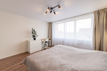 Minimalism Young Adult Living Room Interior. Bed and Coffee Table. Gray Blanket on the Bed. Windows and Curtains. LED Light. Windows and Curtains