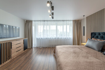 Luxurious master bedroom interior, modern house, beautiful interiors, wide bedroom. TV Set on the Wall