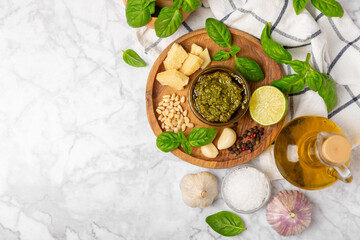 Pesto. Italian basil pesto sauce on a textured wooden background. Ingredient for pesto sauce: fresh...
