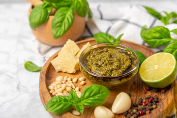 Pesto. Italian basil pesto sauce on a textured wooden background. Ingredient for pesto sauce: fresh...