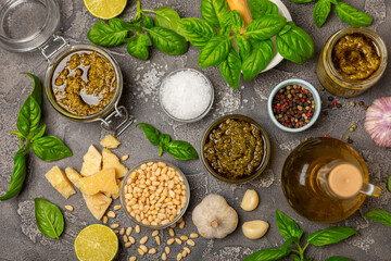 Pesto. Italian basil pesto sauce on a textured wooden background. Ingredient for pesto sauce: fresh basil, pine nuts, Parmesan cheese and olive oil. Space for text.Copy space.