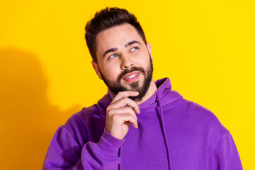 Photo of minded attractive man wear stylish violet clothes look empty space isolated on yellow color background
