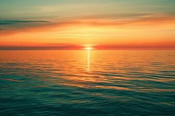 Obraz premium A breathtaking sunset over calm waters, with vibrant orange and gold hues reflected on the rippling ocean surface.
