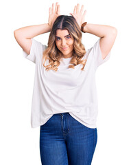 Fototapeta premium Young caucasian woman wearing casual clothes doing bunny ears gesture with hands palms looking cynical and skeptical. easter rabbit concept.