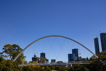 Captivating view of a bridge weaving through lush greenery with Paramata City's skyline as a stunning backdrop. Iconic Australian urban and natural beauty in perfect harmony.