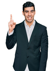 Handsome hispanic man wearing business clothes showing and pointing up with finger number one while smiling confident and happy.