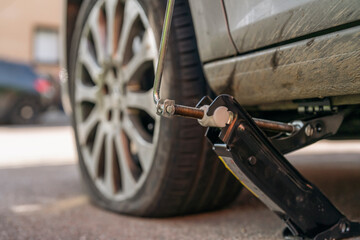 Closeup of Car Jack Lifting Car Tire © Iryna