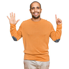 Naklejka premium Hispanic adult man wearing casual winter sweater showing and pointing up with fingers number six while smiling confident and happy.