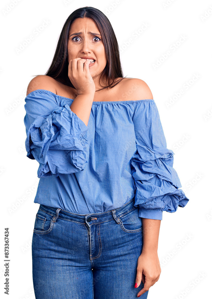 Wall mural Young beautiful brunette woman wearing casual t-shirt looking stressed and nervous with hands on mouth biting nails. anxiety problem.