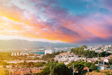 Beautiful Cityscape Of Turkish Town near warm sea. White Residential Houses On Hillside. Real Estate Suburb In Summer Evening