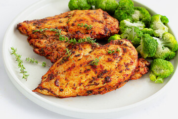 Baked Chicken Breast and Broccoli on a Plate Garnished with Fresh Thyme