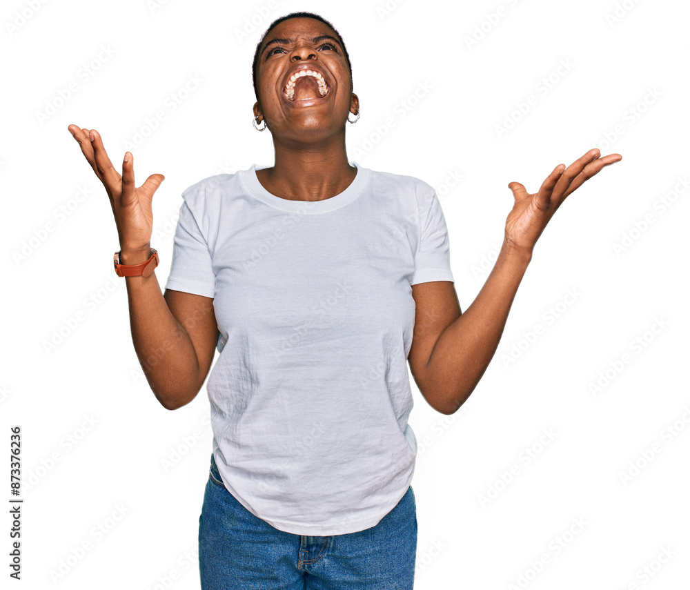 Sticker Young african american woman wearing casual white t shirt crazy and mad shouting and yelling with aggressive expression and arms raised. frustration concept.