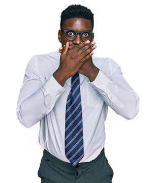 Handsome business black man wearing white shirt and tie shocked covering mouth with hands for mistake. secret concept.