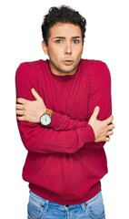 Young handsome man wearing casual clothes shaking and freezing for winter cold with sad and shock...