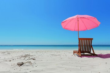 A peaceful beach scene with a pink umbrella and wooden chair facing the calm, clear ocean under a cloudless blue sky. Perfect for relaxation and tranquility.