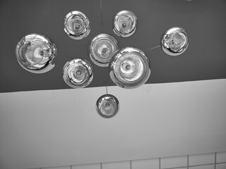 Modern chandelier background, round lamps over ceiling pattern, black and white monochrome photo