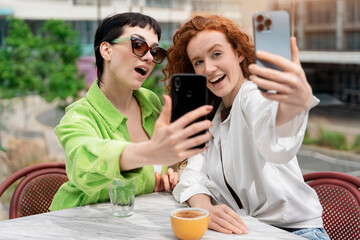 Two Women Taking Selfie at Outdoor Cafe During Day