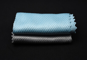 Blue and gray wiping cloths on a black background.