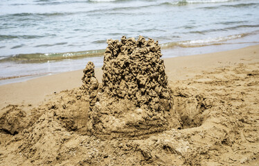 Built sand castle house on the shore of a sandy beach