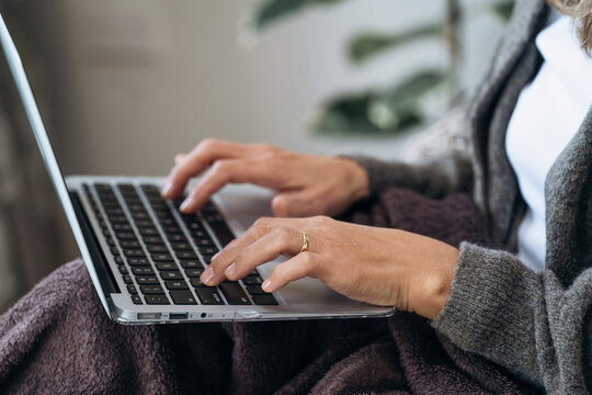 Woman Typing on Laptop While Wearing Grey Sweater