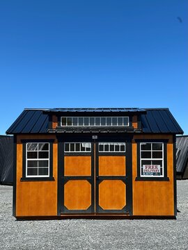 American style wooded shed. A shed is typically simple, single-story roofed structure in a back garden or on an allotment that is used for storage, hobbies, or as a workshop.