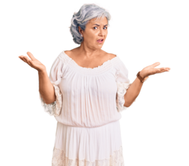 Senior woman with gray hair wearing bohemian style clueless and confused with open arms, no idea concept.