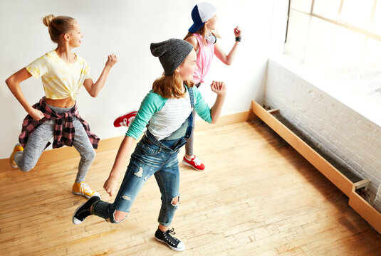 Girl, teen friends and dancing together for bonding, funky fashion and fun workout with teamwork in studio. Teenager, people and above practice for dance competition, streetwear clothes and talent