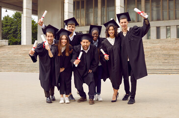 Portrait of a group of smiling laughing happy multiracial international graduates students standing...