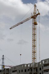 view of a residential complex under construction against the backdrop of a construction crane, standard condos for the middle class, housing concept