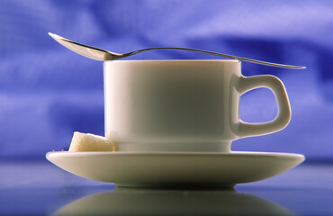 Cup plate pieces of sugar and spoon.