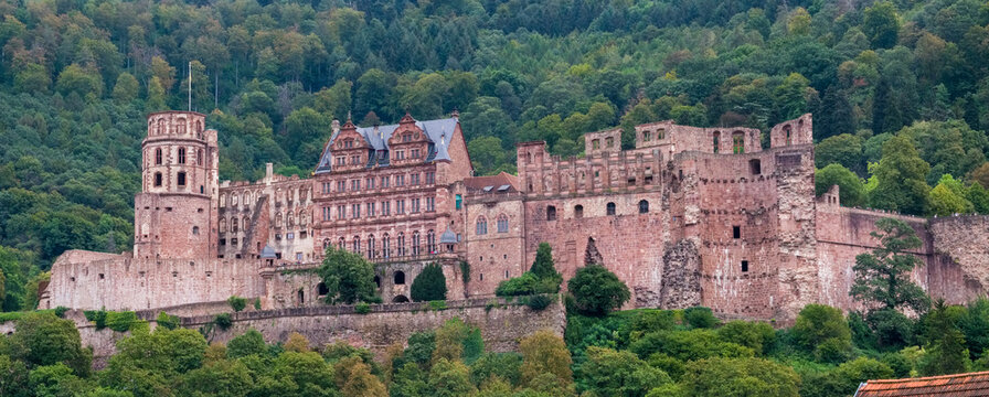 A castle with a large tower and a lush green hillside