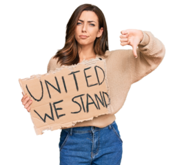 Young brunette woman holding united we stand banner with angry face, negative sign showing dislike with thumbs down, rejection concept