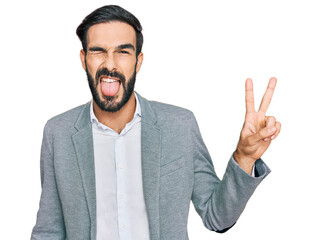 Young hispanic man wearing business clothes smiling with happy face winking at the camera doing...