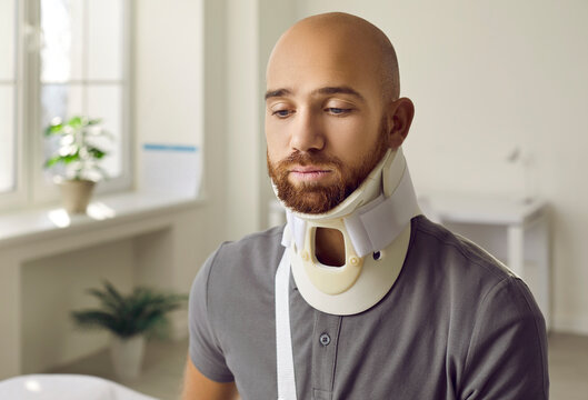 Unwell young Caucasian man with neck collar suffer from back fracture or trauma. Unhealthy injured immobilized guy with protective surgical bandage after accident or injury. Healthcare.