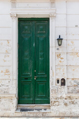 A green door with a white trim sits in front of a building