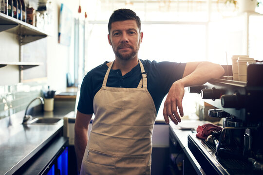 Waiter, man and serious on portrait in cafe for customer service, hospitality and coffee shop startup. Small business, barista and server at counter with ready to welcome, bistro management or pride