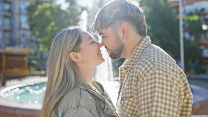 Fototapeta premium A young couple embraces outdoors, exuding love and closeness in a sunlit park, emanating romance