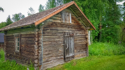 Ancient wooden hut surrounded by greenery in Finland