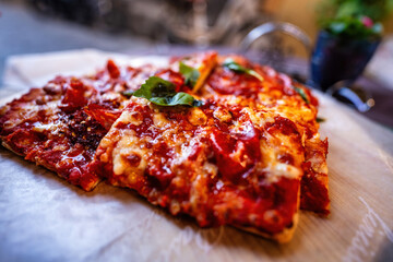 Board with pieces of delicious pizza Diablo on wooden table, side selective focus view