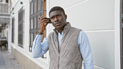 African american man using smartphone in urban city street setting, portraying modern communication.